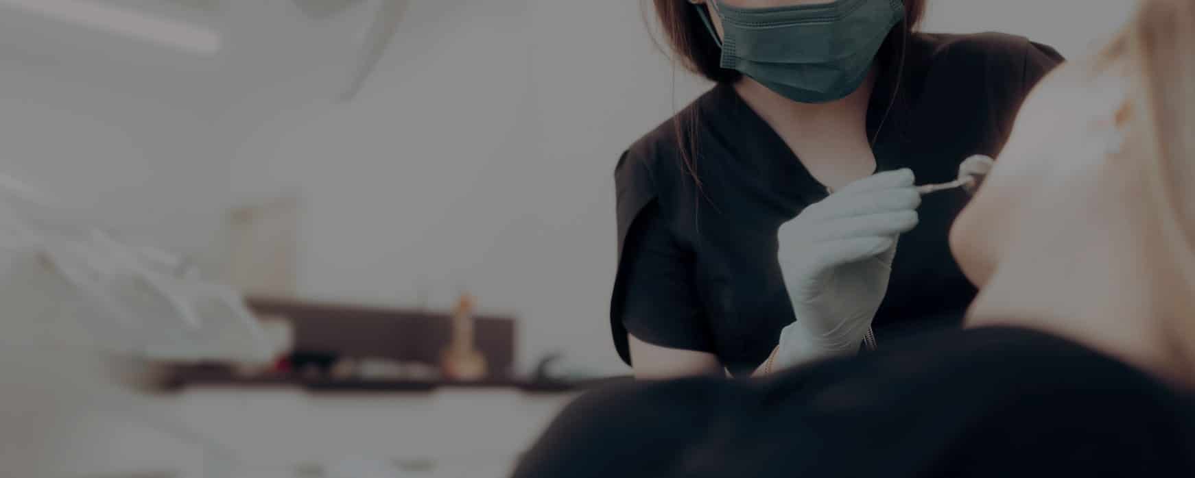 dental hygienists holding tools up to dental patients mouth during a teeth cleaning